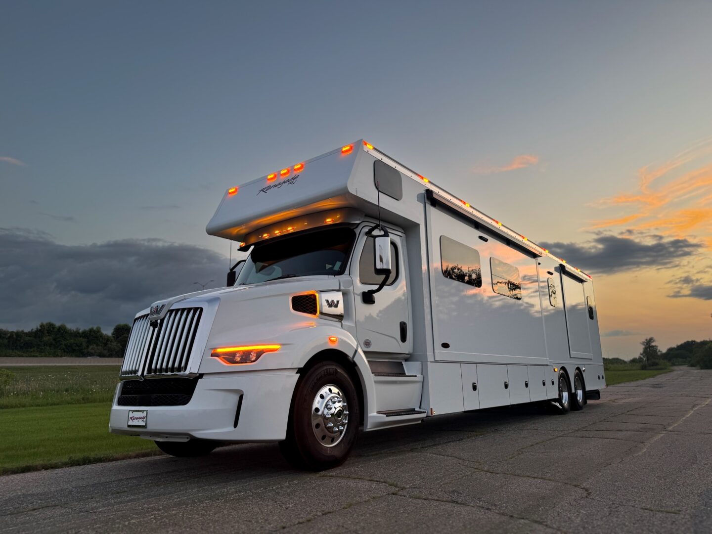 Luxury white motorhome on scenic road.
