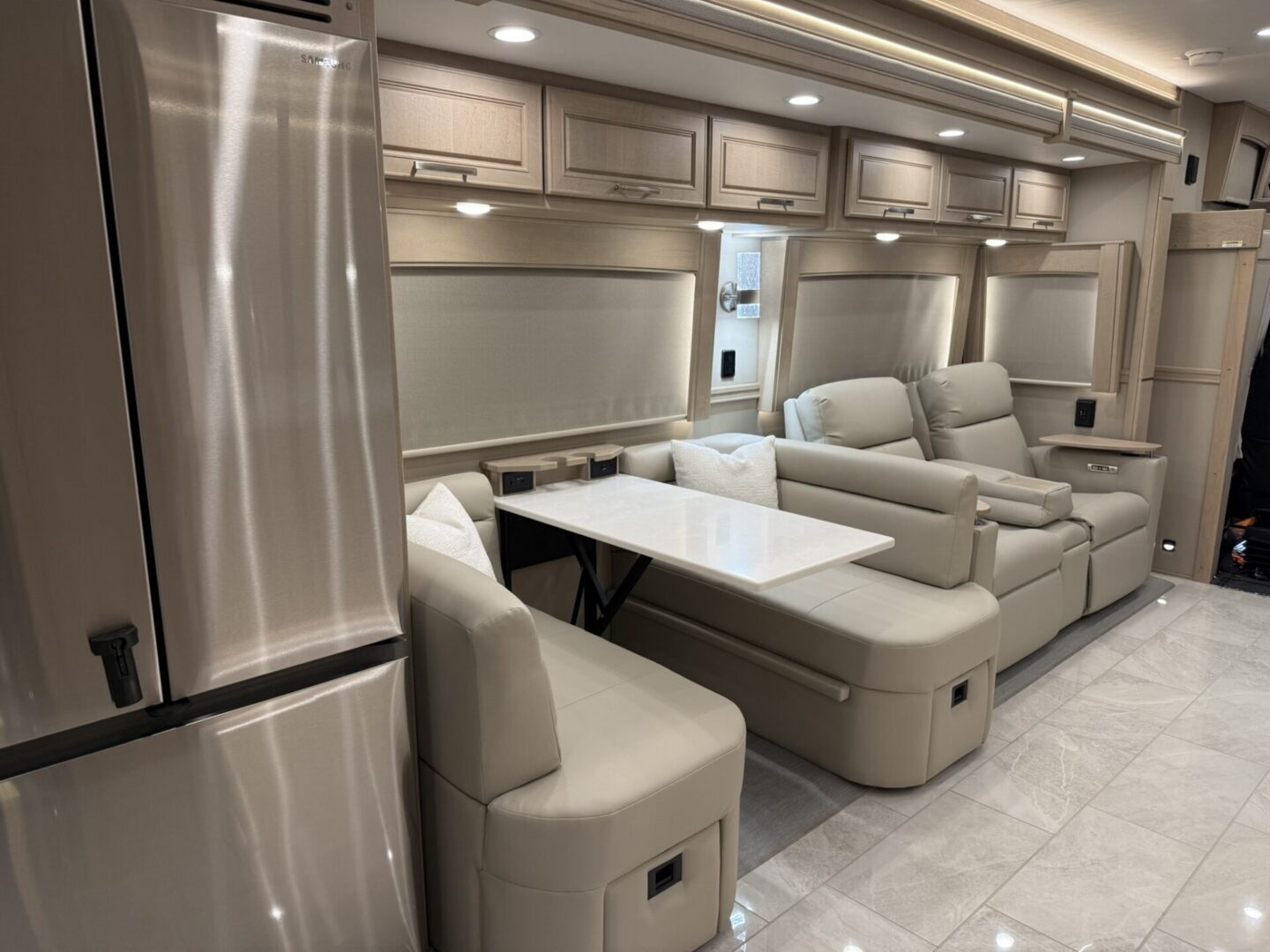 Modern RV interior with seating and table.