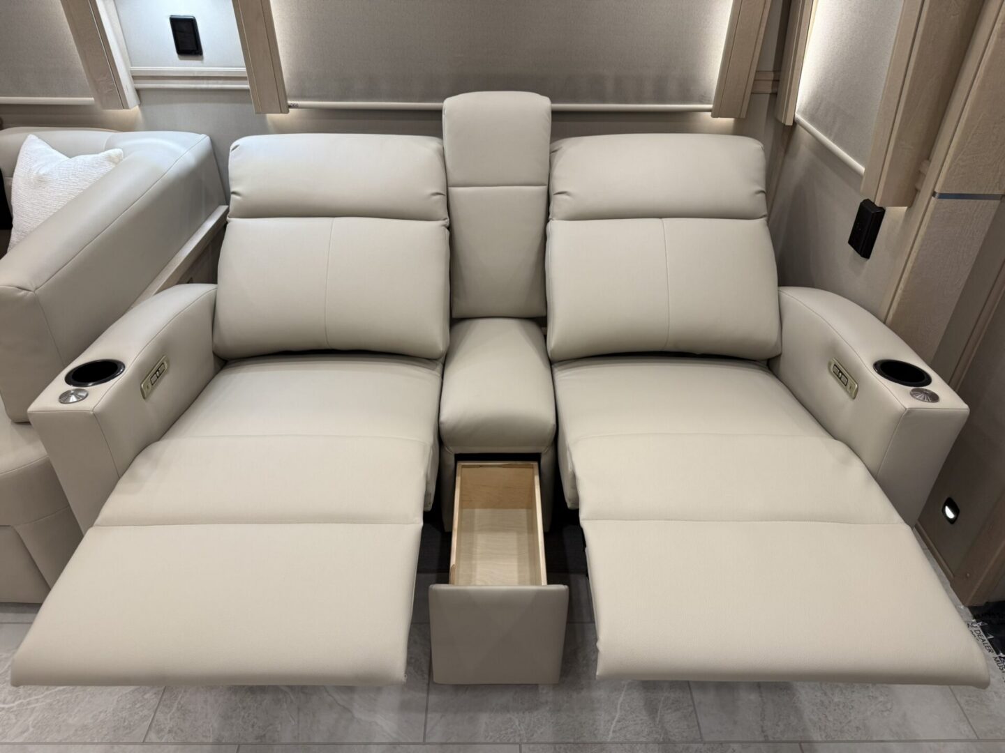 Reclining cream leather sofa with cup holders.