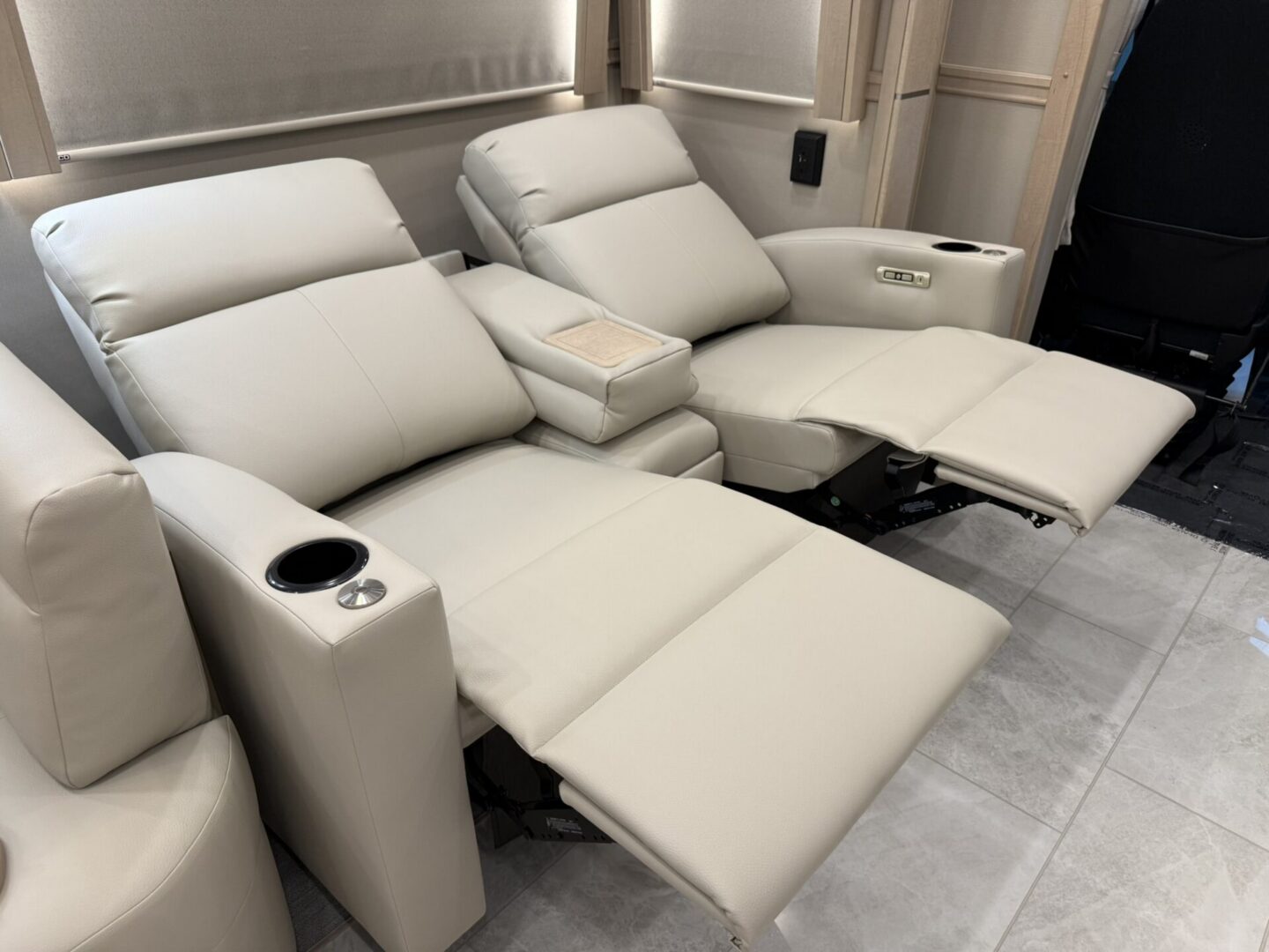 Reclining beige chairs with cup holders.