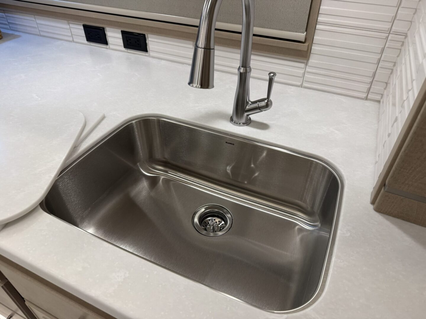 Stainless steel kitchen sink with faucet.