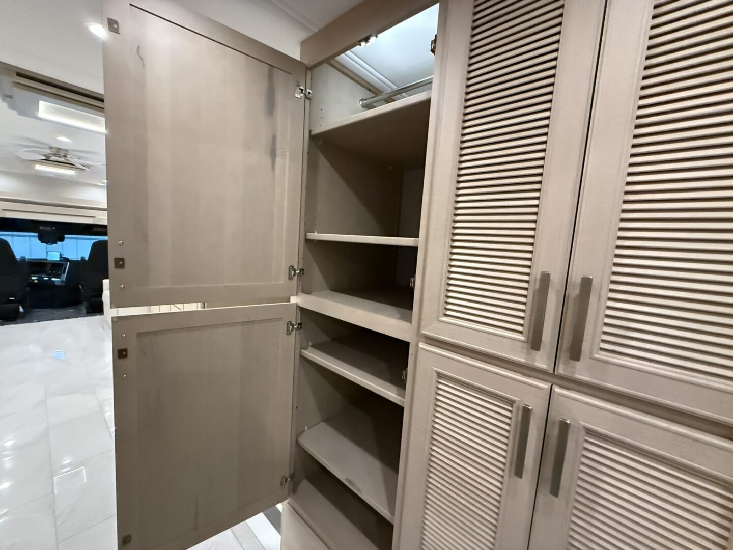 Open cabinet with shelves and textured doors.