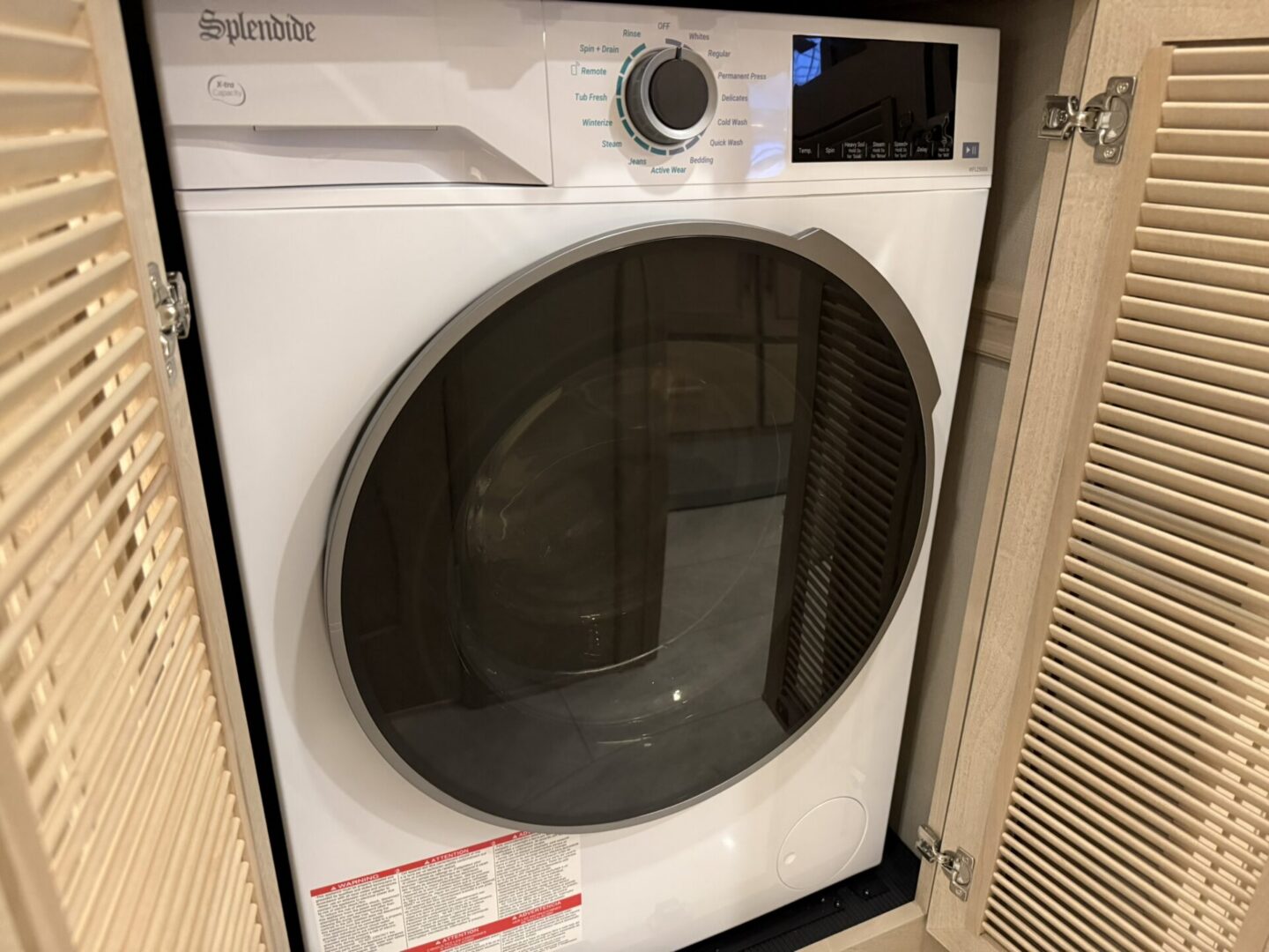 White washing machine in cabinet space.