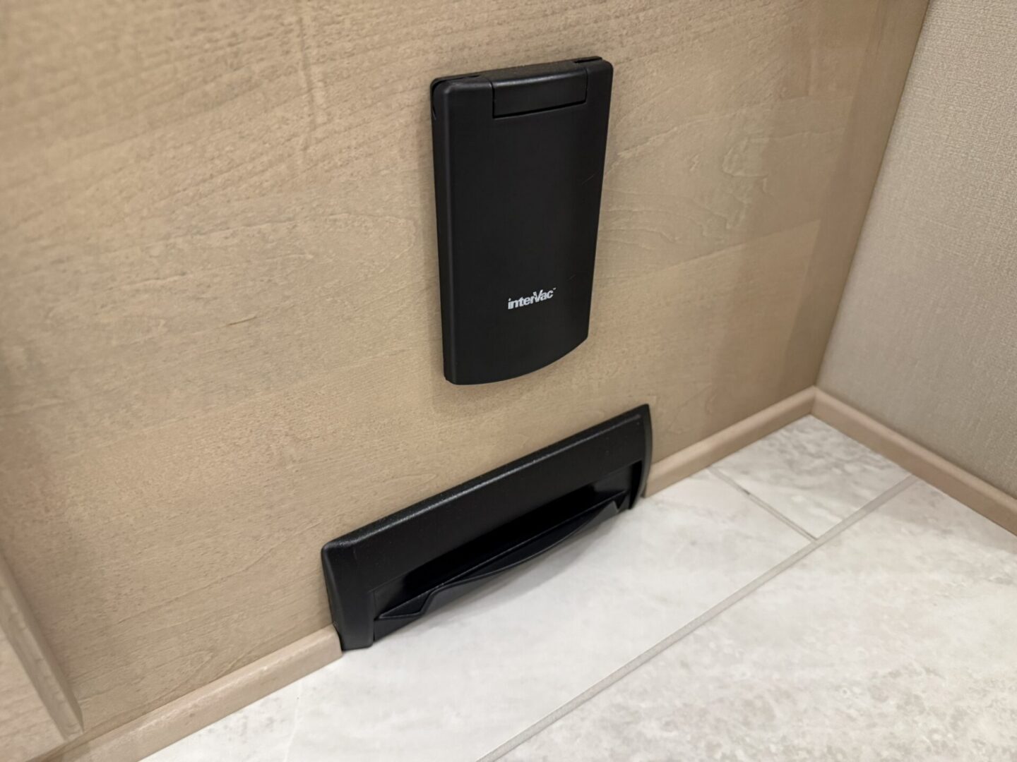 Black wall-mounted device and drawer handle.