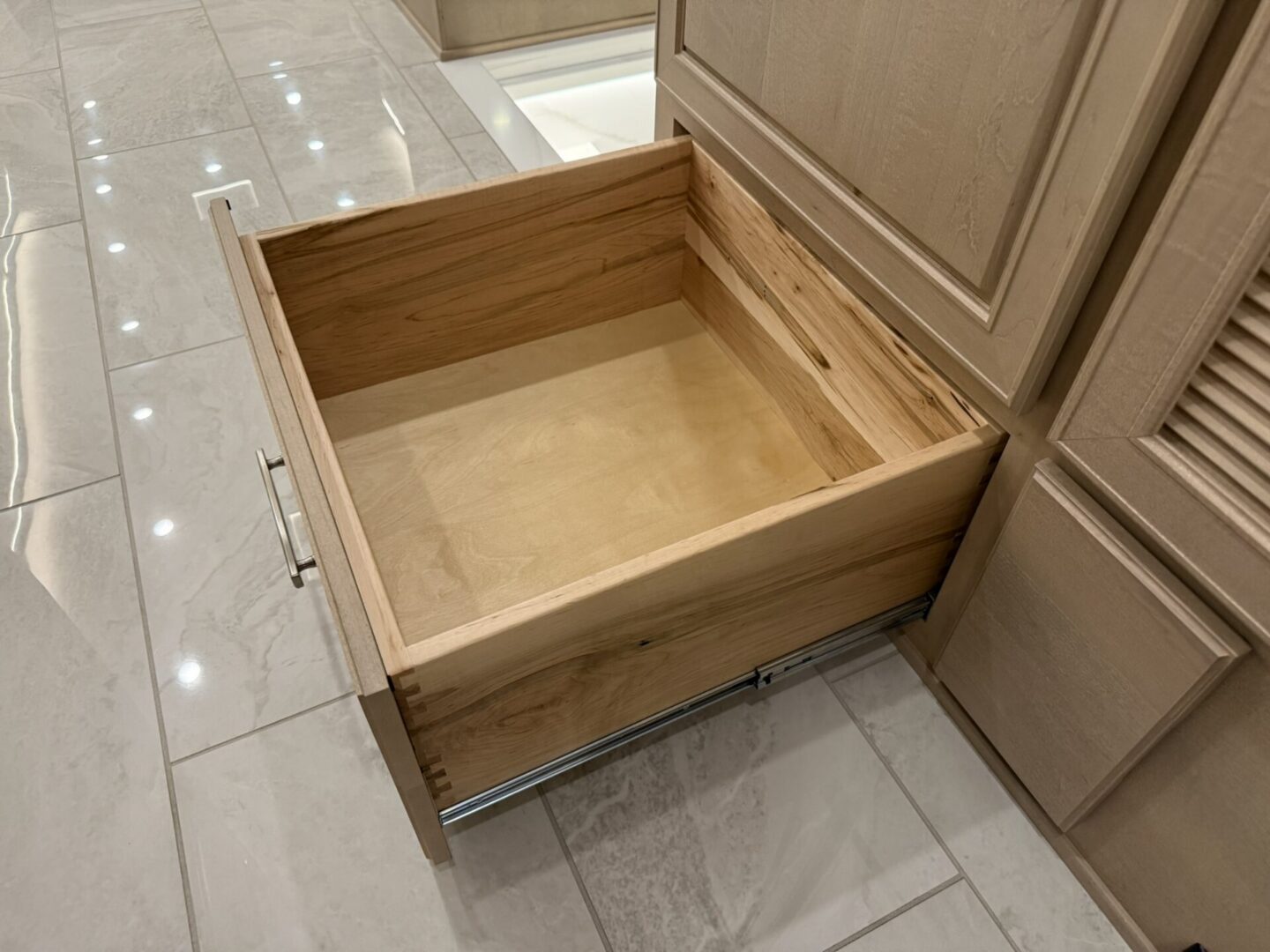 Open wooden drawer in modern kitchen.