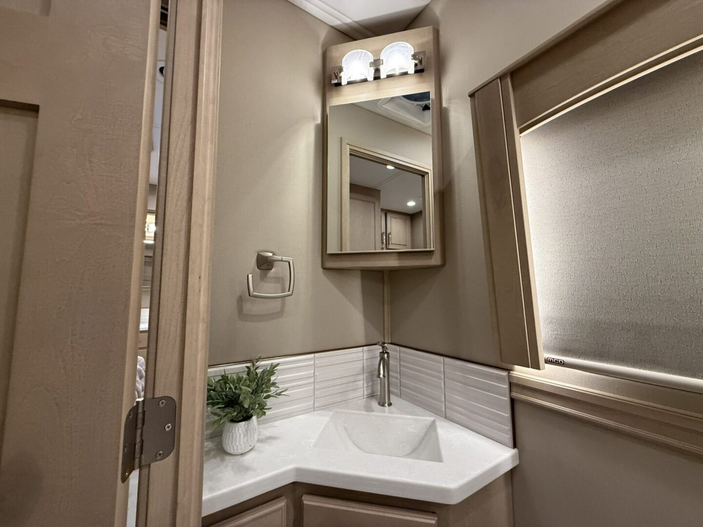 Modern bathroom with corner sink and mirror.