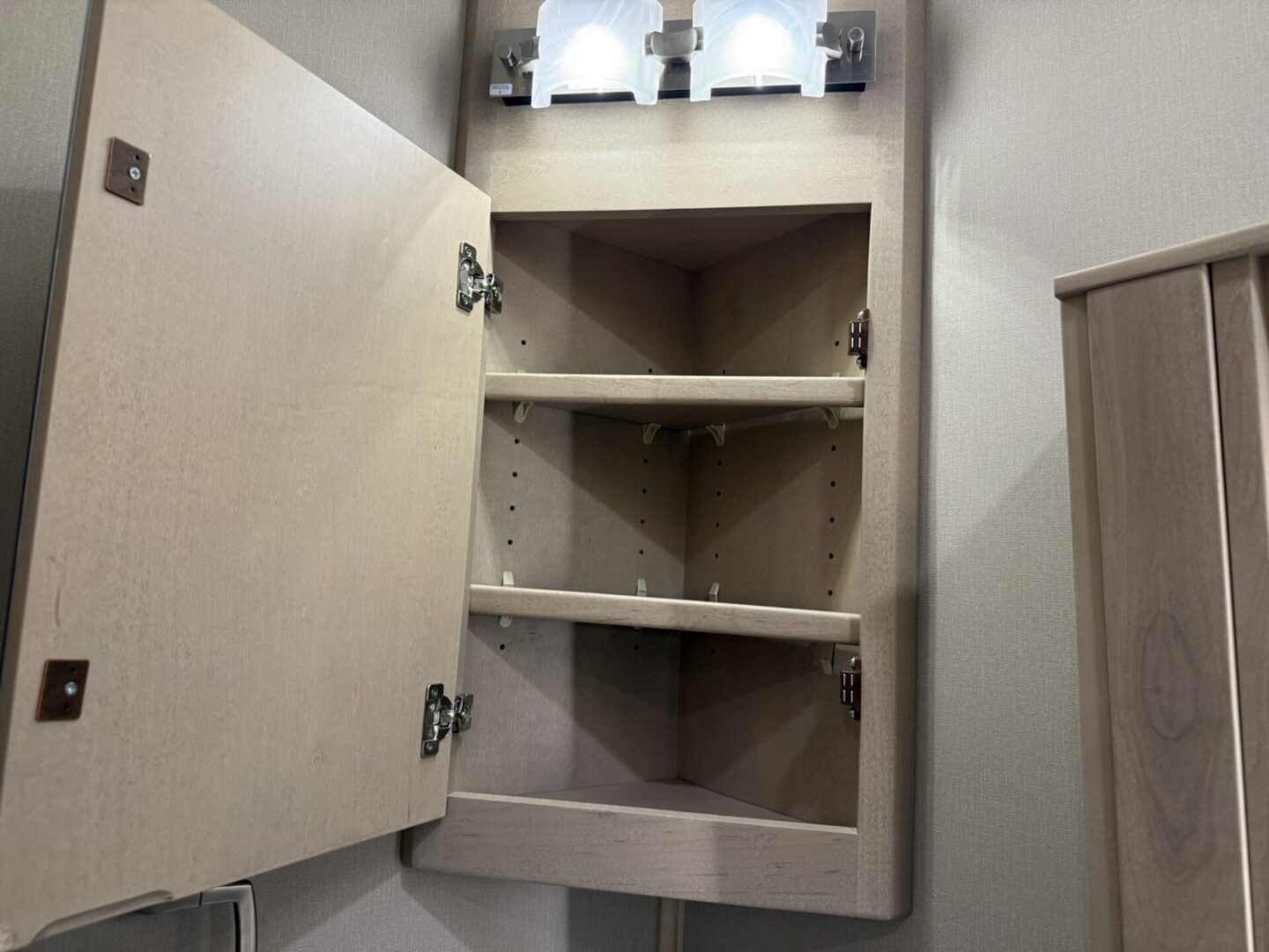 Open cabinet with shelves and lights.