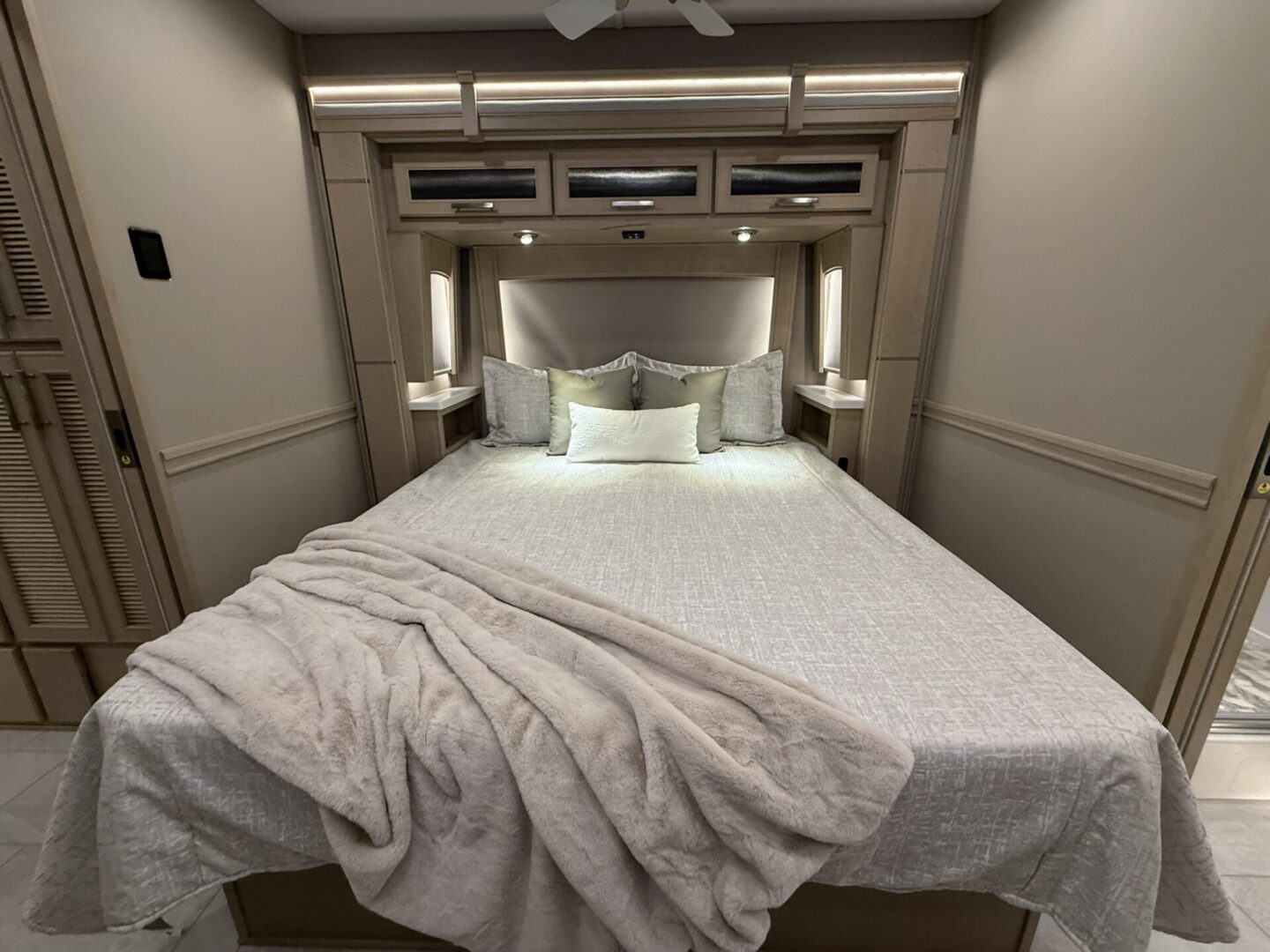 Cozy bedroom with soft bedding and lighting.